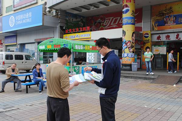 图为:司法社工通过派发宣传单张向居民普法